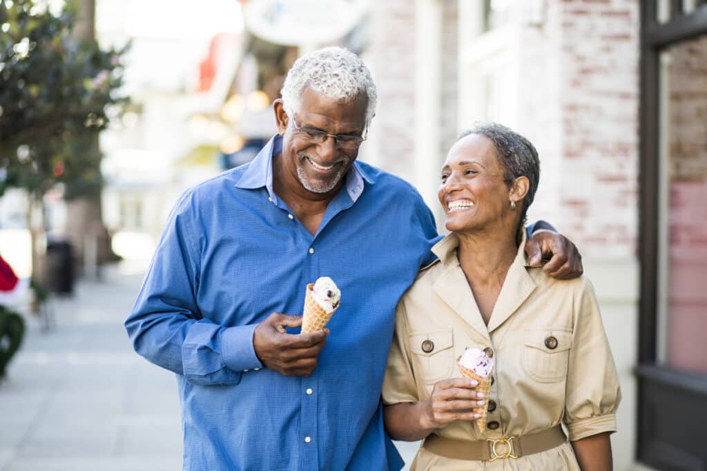 A couple walk through a boutique shopping district enjoying ice cream cones
