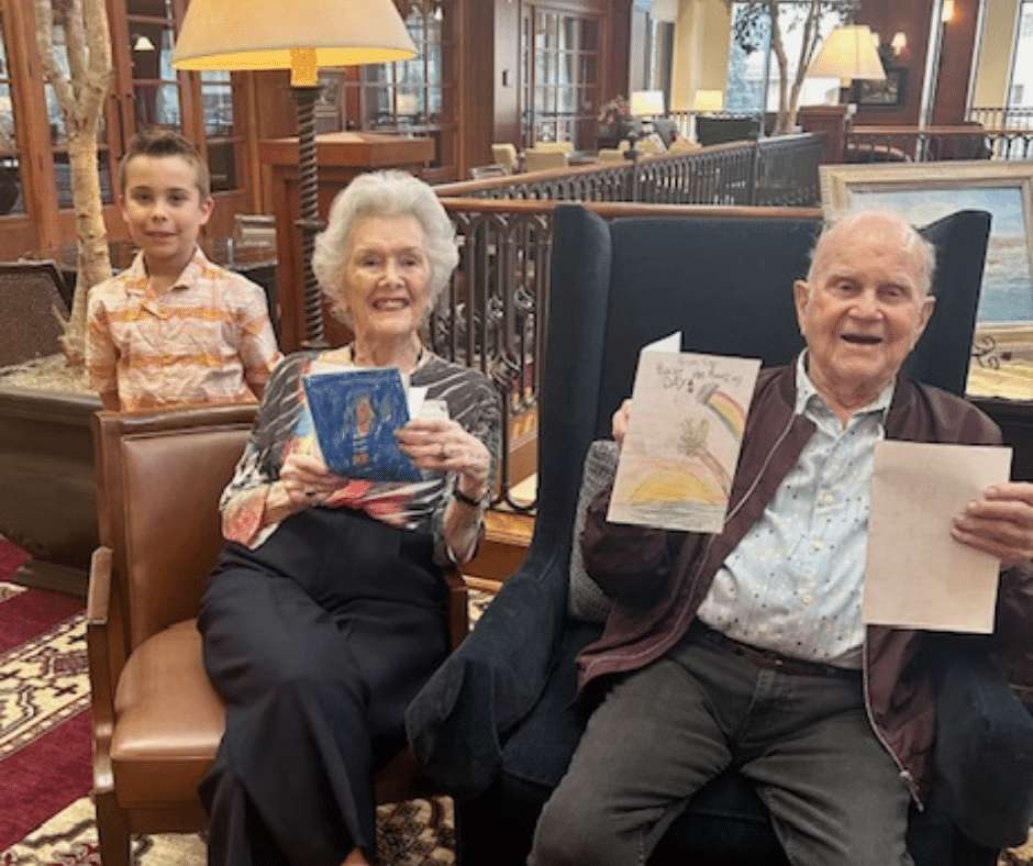 Seniors at University Village show off the homemade cards grade schoolers made for them