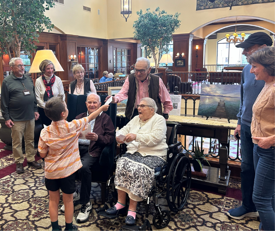 A senior man and woman sitting on a couch laughing together.