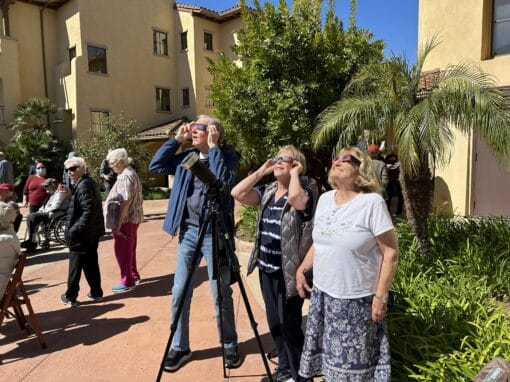 UVTO Residents outside looking at the eclipse with eclipse glasses.